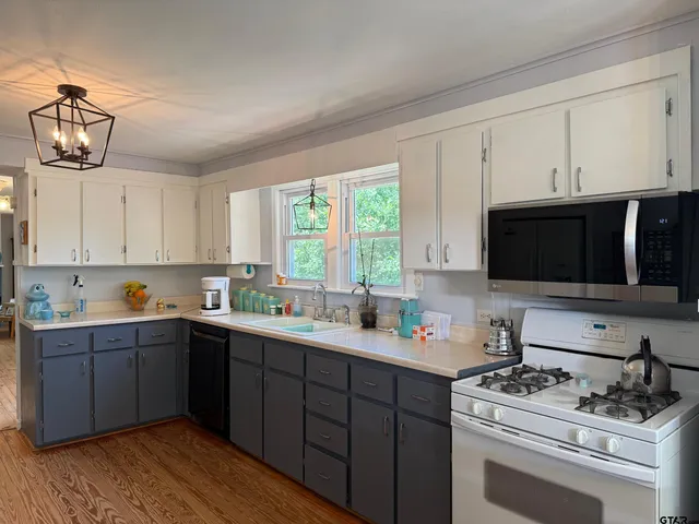 a large kitchen with kitchen island granite countertop a sink and a stove top oven
