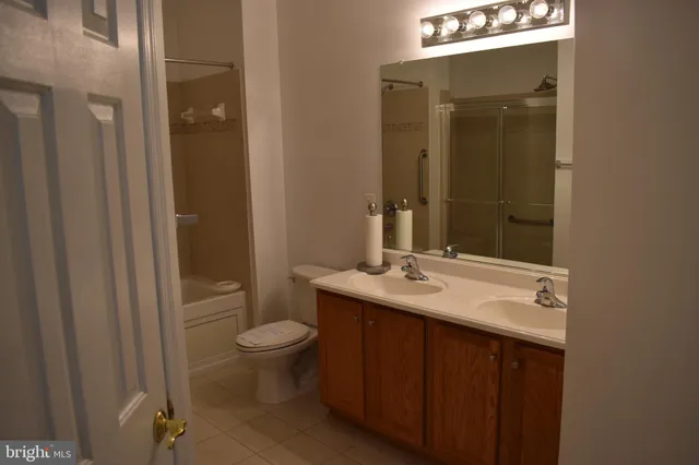 a bathroom with a granite countertop sink toilet and mirror