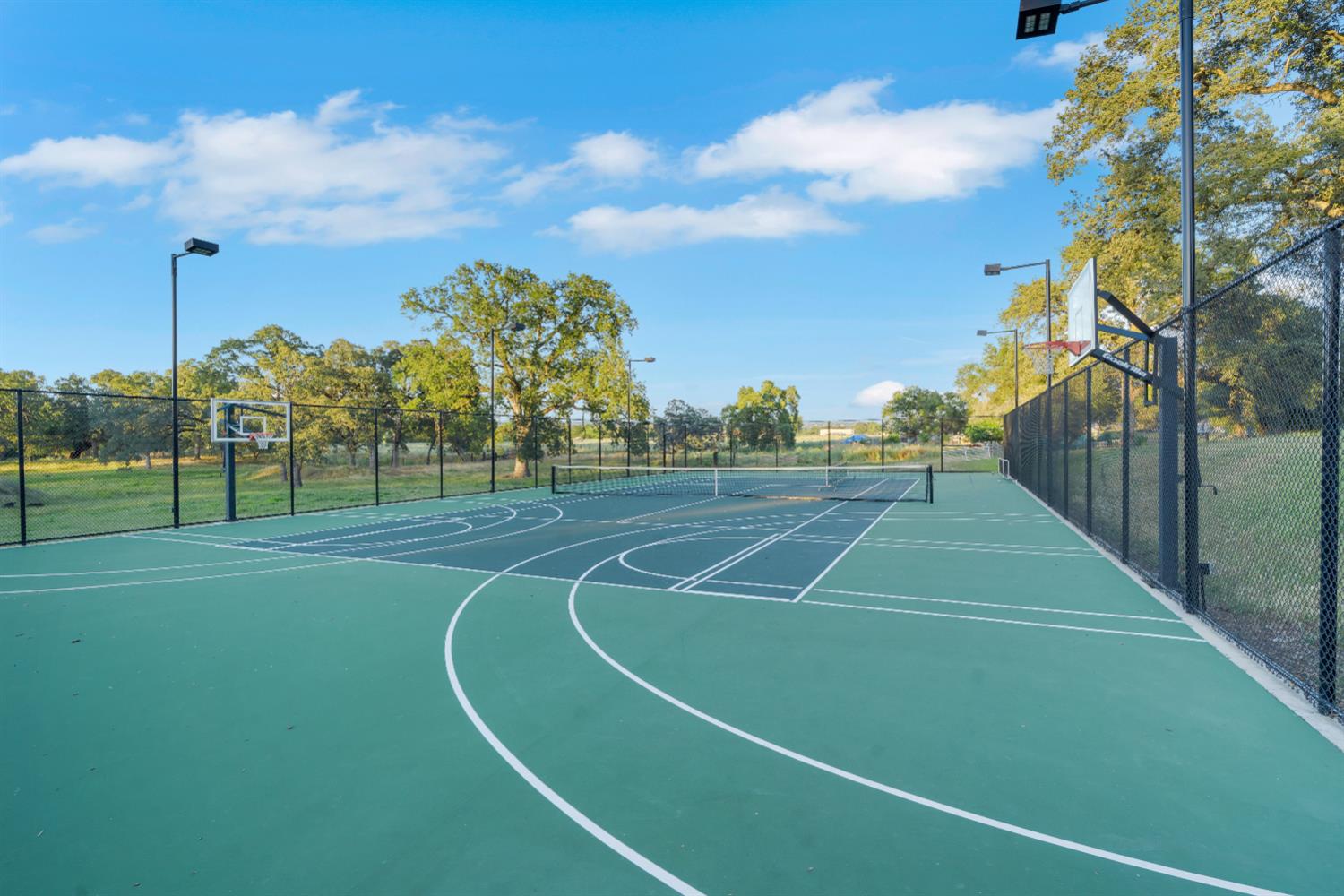 2905 Virginiatown Road Lincoln, CA 95648 - Photo 6 of 86 Multi-sport court featuring a tennis net, basketball hoops, and perimeter fencing and lighting