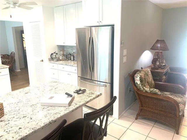 a kitchen with stainless steel appliances kitchen island granite countertop a refrigerator and a stove top oven