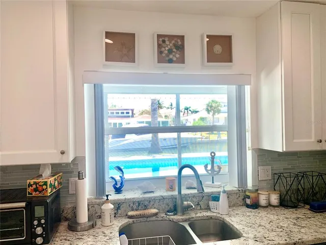 a kitchen with stainless steel appliances granite countertop a sink stove and cabinets