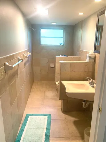 a kitchen with a stove a sink and a refrigerator with wooden floor