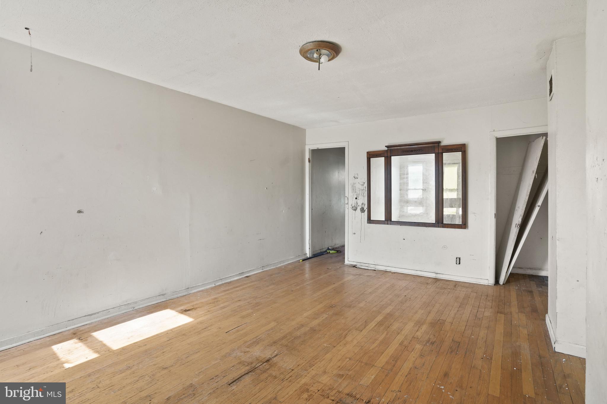 2121 Division Street Baltimore, MD 21217 - Photo 4 of 18 a view of an empty room with wooden floor and a window