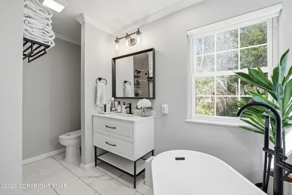 a spacious bathroom with a toilet a sink and a mirror