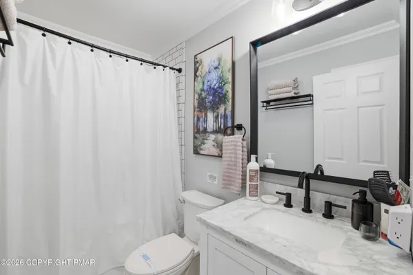 a bathroom with a granite countertop sink toilet and shower