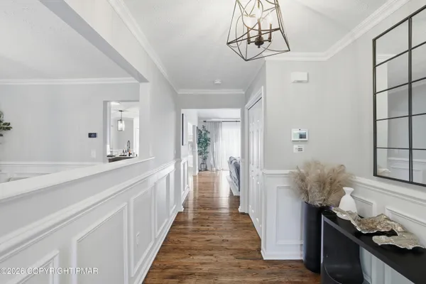 a view of a hallway to a livingroom and a chandelier