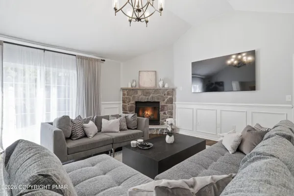 a living room with furniture a flat screen tv and a fireplace