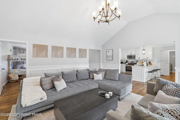a living room with furniture wooden floor and a chandelier