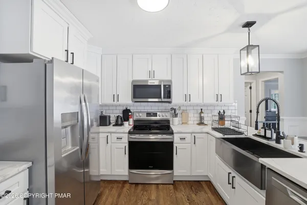 a kitchen with white cabinets and stainless steel appliances