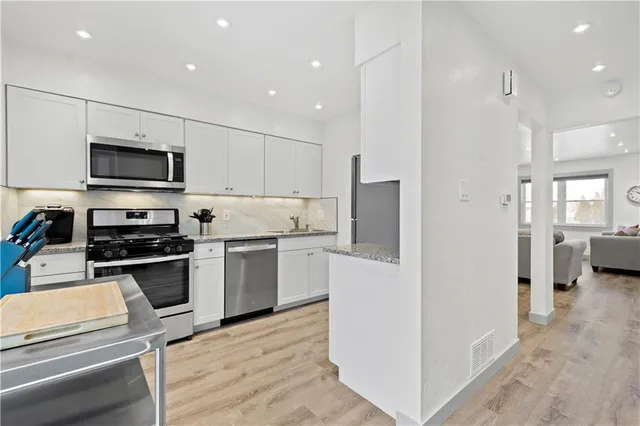 a kitchen with a sink stainless steel appliances and cabinets