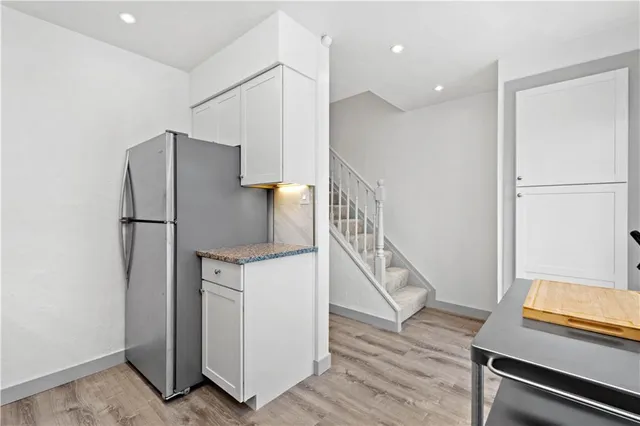 a kitchen with wooden floor and electronic appliances