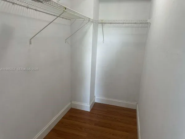 an empty room with wooden floor and closet