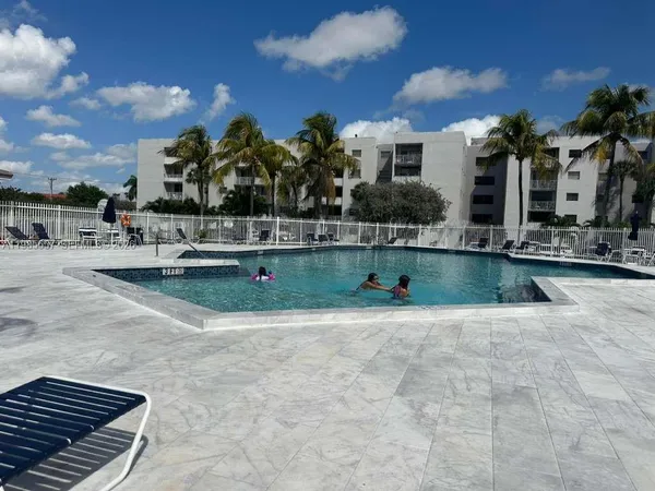 a swimming pool with outdoor seating and barbeque oven