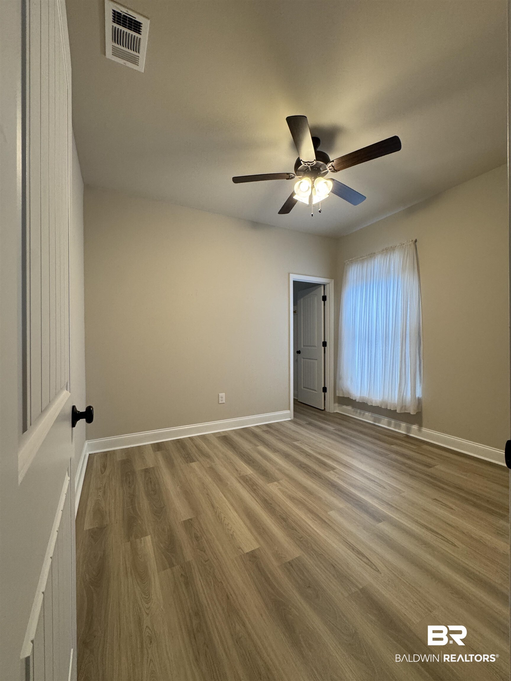 1060 Chloe Street Foley, AL 36535 - Photo 19 of 28 Neutral tone walls, white trim, and a ceiling fan with integrated lighting