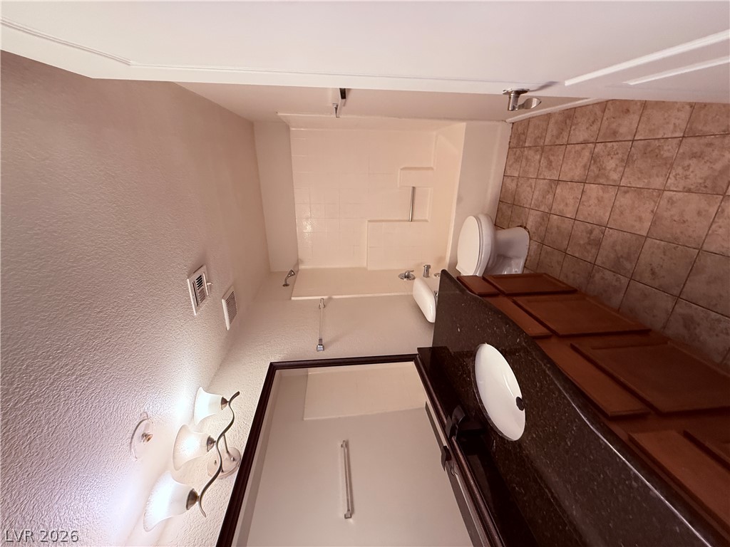 9325 West Desert Inn Road, Unit 260 Las Vegas, NV 89117 - Photo 13 of 42 A well-appointed bathroom offers a single vanity with ample counter space and a classic tiled floor.