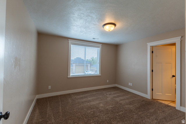 3565 West 1350th Street North Vernal, UT 84078 - Photo 24 of 54 Carpeted room featuring a single window with blinds, a flush mount ceiling light, and a white interior door