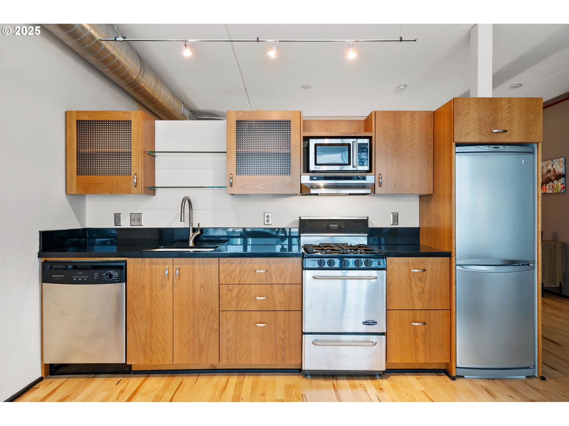 333 Northwest 9th Avenue, Unit 411 Portland, OR 97209 - Photo 14 of 32 a kitchen with stainless steel appliances granite countertop a refrigerator a stove and a sink