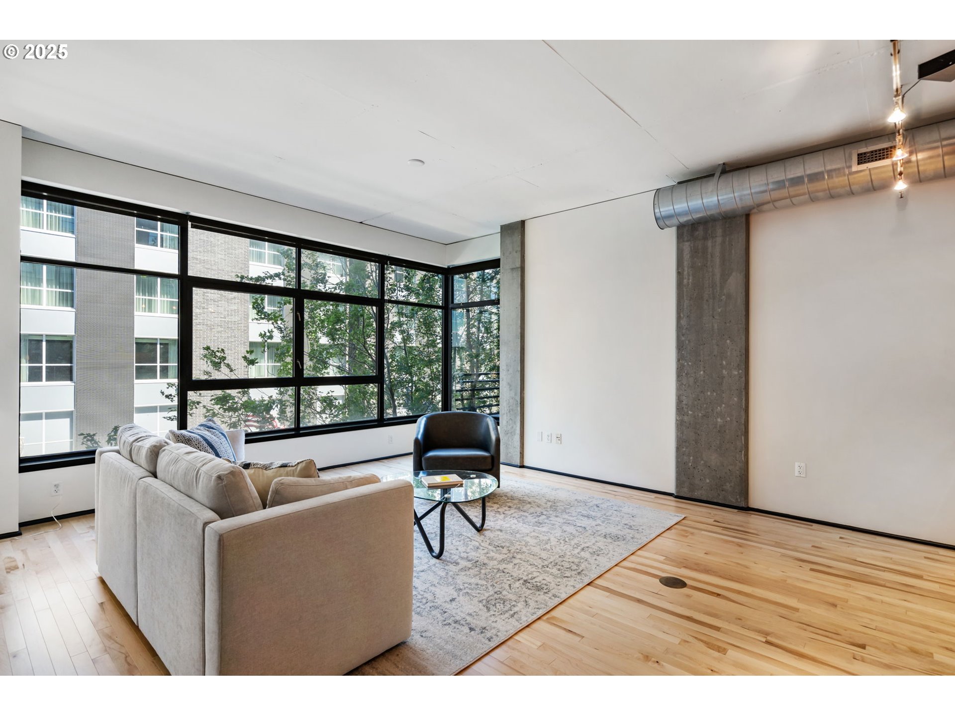 333 Northwest 9th Avenue, Unit 411 Portland, OR 97209 - Photo 6 of 32 a living room with furniture floor to ceiling window and wooden floor