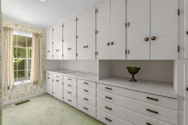 a kitchen with granite countertop white cabinets and window