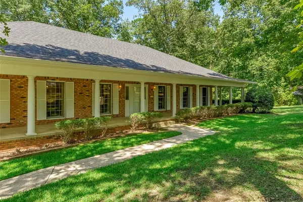 a view of a house with backyard garden and sitting area