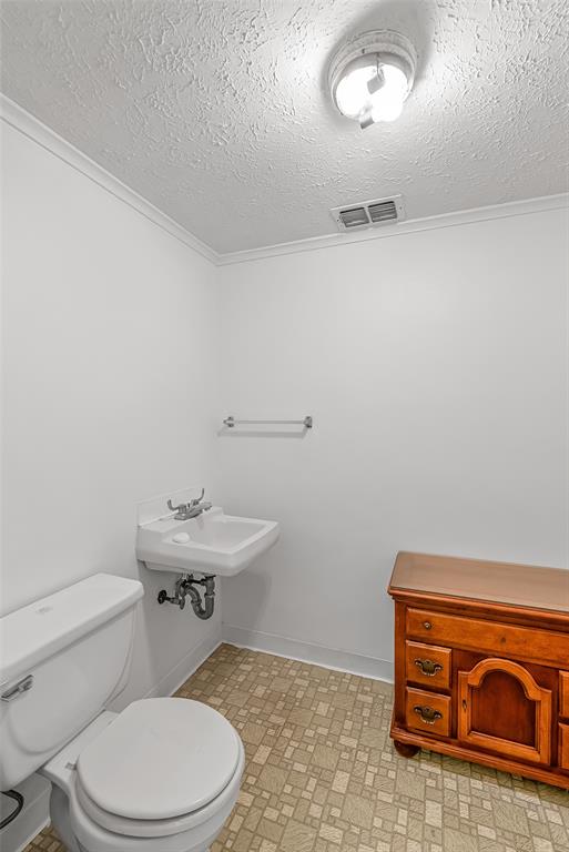 741 Beverly Drive Homer, LA 71040 - Photo 24 of 30 a bathroom with a toilet a sink and mirror