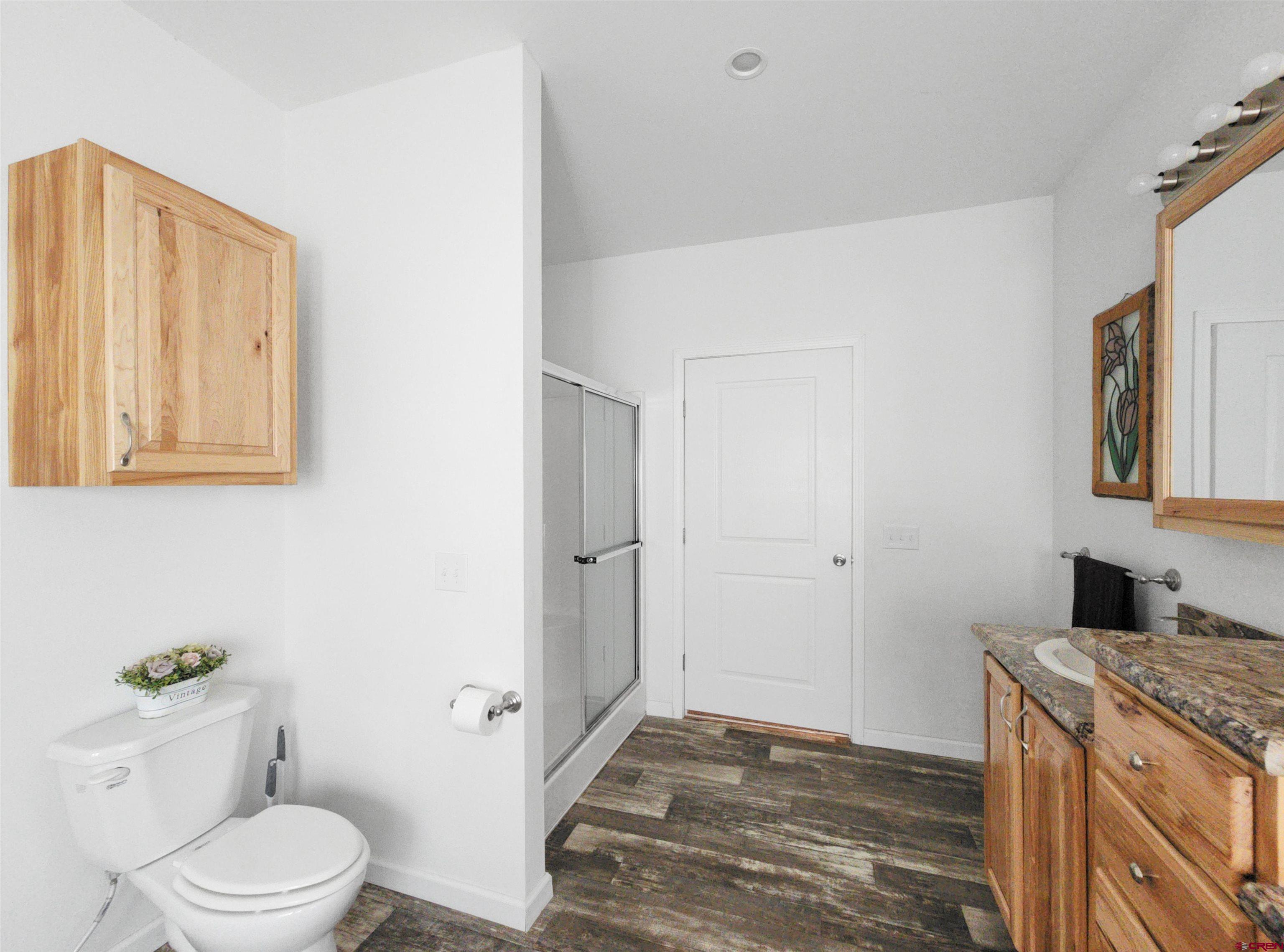 28454 Lampshire Road Hotchkiss, CO 81419 - Photo 16 of 45 a bathroom with a granite countertop sink toilet and shower