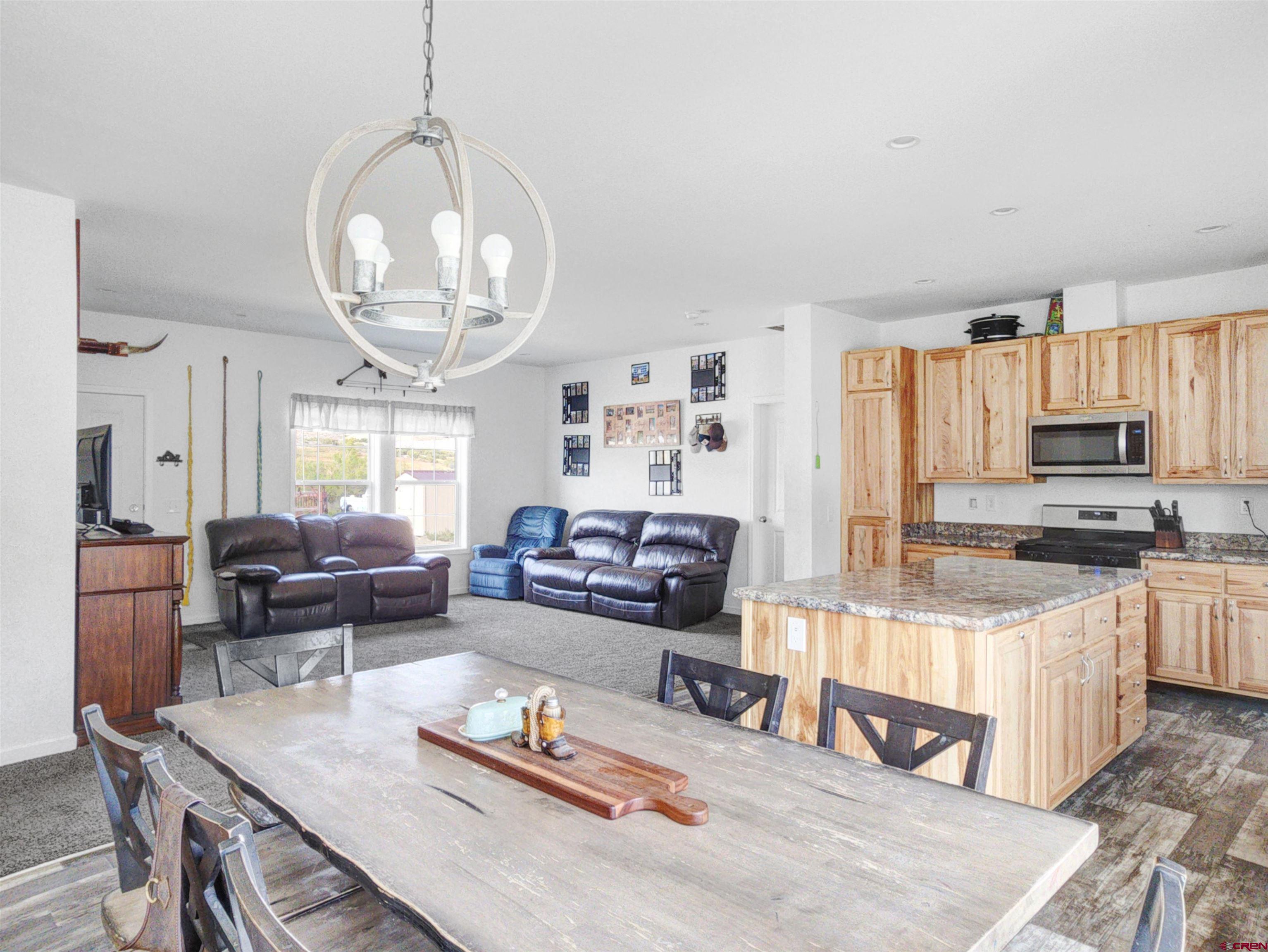 28454 Lampshire Road Hotchkiss, CO 81419 - Photo 2 of 45 a living room with kitchen island furniture and a chandelier