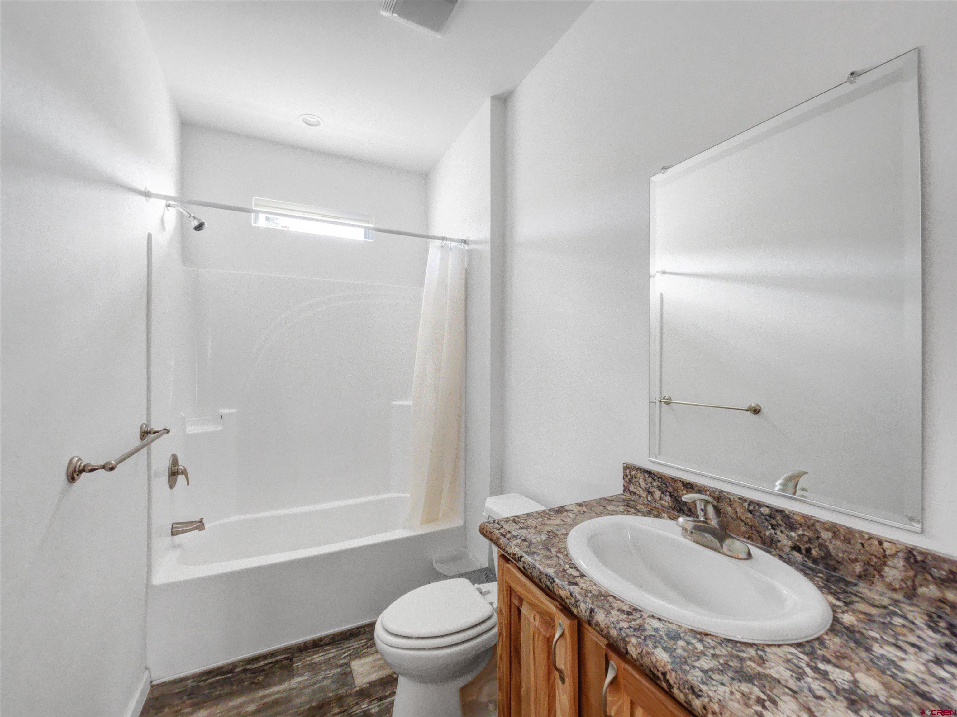 28454 Lampshire Road Hotchkiss, CO 81419 - Photo 29 of 45 a bathroom with a granite countertop sink toilet mirror and shower