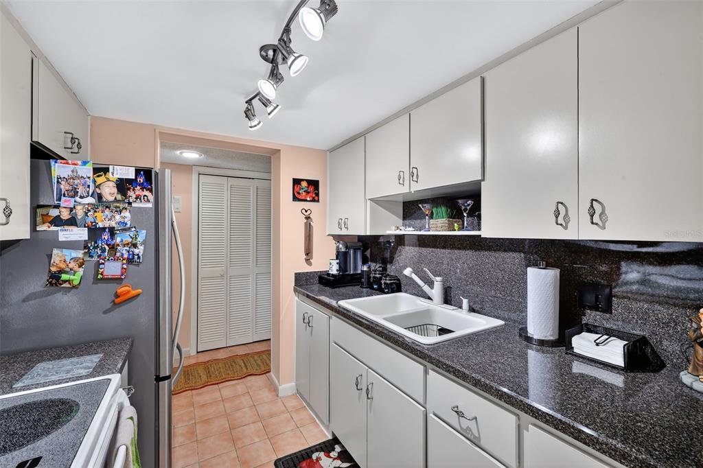 5541 Bay Boulevard, Unit 203 Port Richey, FL 34668 - Photo 14 of 30 a kitchen with stainless steel appliances granite countertop a sink stove and refrigerator