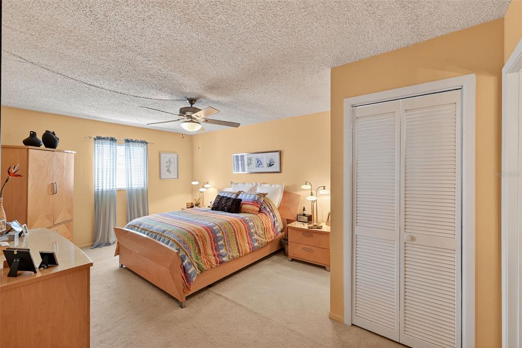 5541 Bay Boulevard, Unit 203 Port Richey, FL 34668 - Photo 15 of 30 a bedroom with a bed and a chandelier