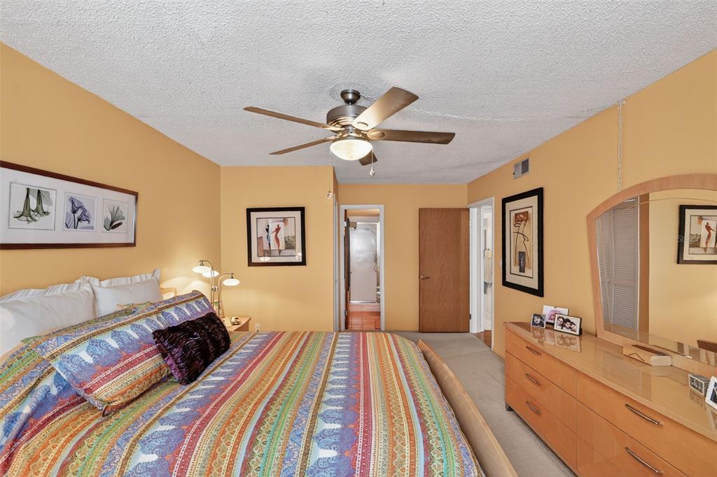 5541 Bay Boulevard, Unit 203 Port Richey, FL 34668 - Photo 17 of 30 a spacious bedroom with a bed and a chandelier