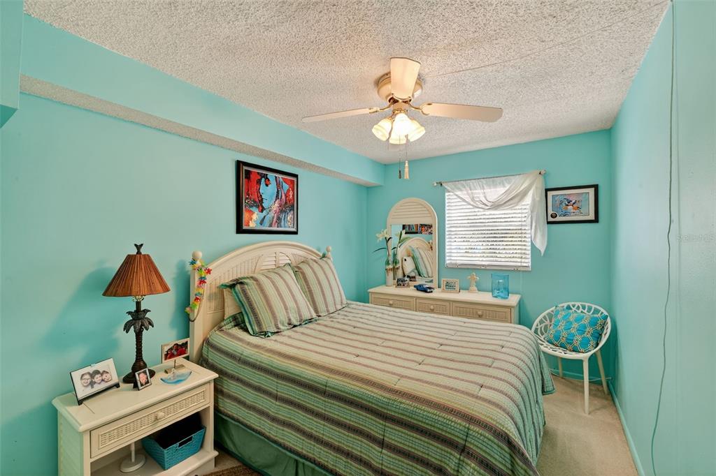 5541 Bay Boulevard, Unit 203 Port Richey, FL 34668 - Photo 19 of 30 a bedroom with a bed and a chandelier