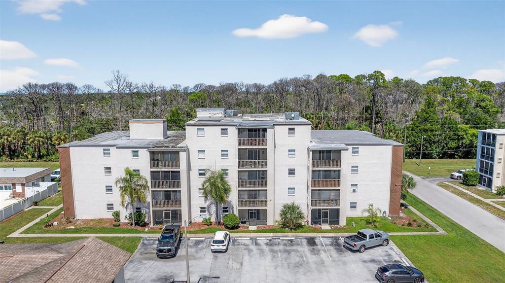 5541 Bay Boulevard, Unit 203 Port Richey, FL 34668 - Photo 30 of 30 a front view of a building with a garden and plants