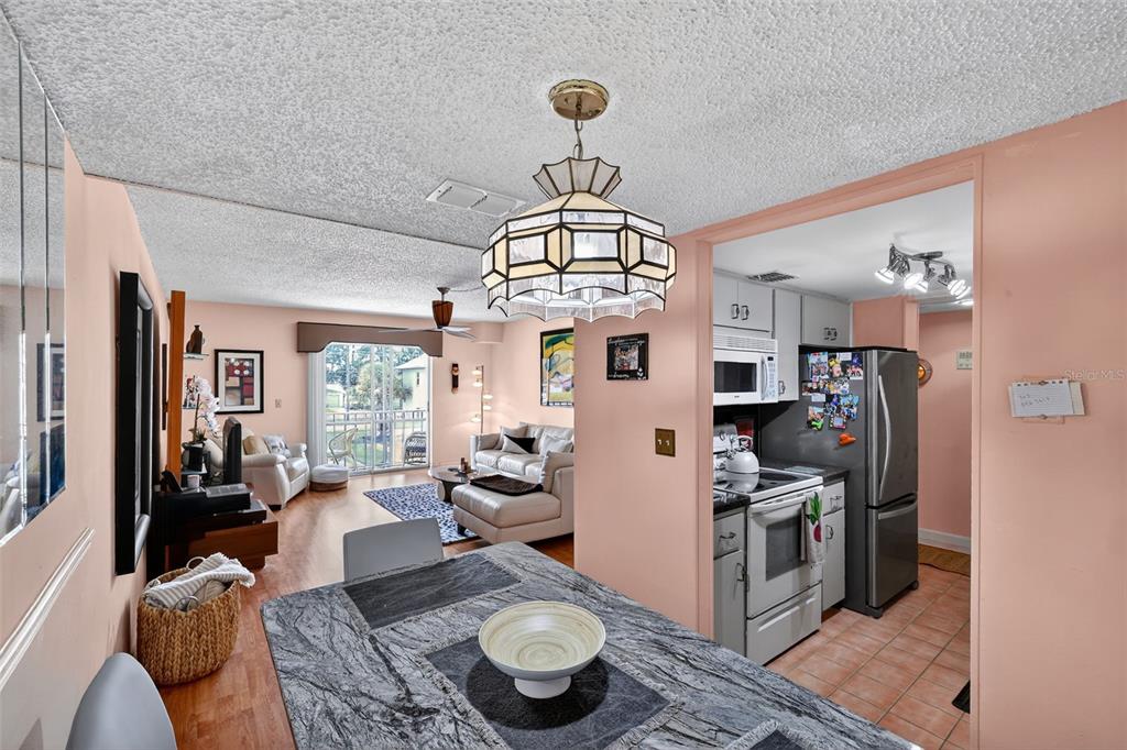 5541 Bay Boulevard, Unit 203 Port Richey, FL 34668 - Photo 8 of 30 a living room with furniture a rug and a chandelier