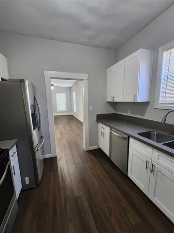 a kitchen with sink cabinets and wooden floor