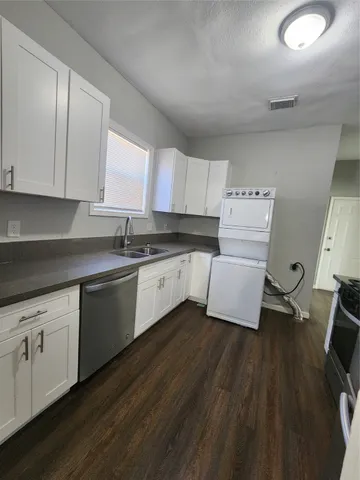 a kitchen with sink cabinets and wooden floor