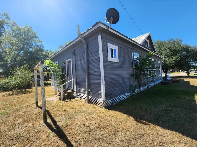 a backyard of a house with barbeque oven table and chairs