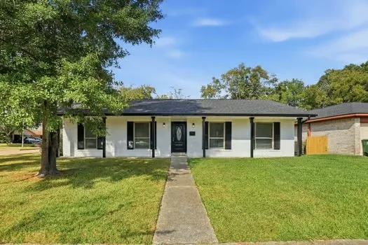 a front view of a house with a yard and trees