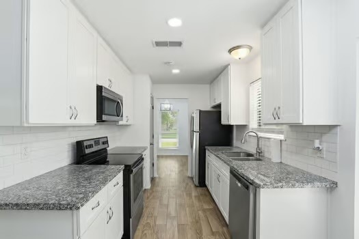 703 Reseda Drive Houston, TX 77062 - Photo 13 of 25 a kitchen with stainless steel appliances granite countertop a sink stove and refrigerator