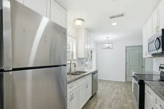 a bathroom with a granite countertop sink a mirror and a shower