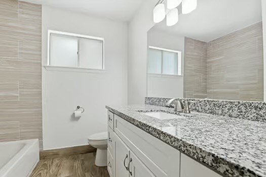 703 Reseda Drive Houston, TX 77062 - Photo 21 of 25 a bathroom with a granite countertop sink a toilet and shower