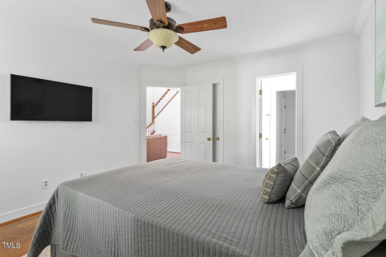 1433 Quarter Point Raleigh, NC 27615 - Photo 16 of 27 a bedroom with a bed a flat screen tv and a window