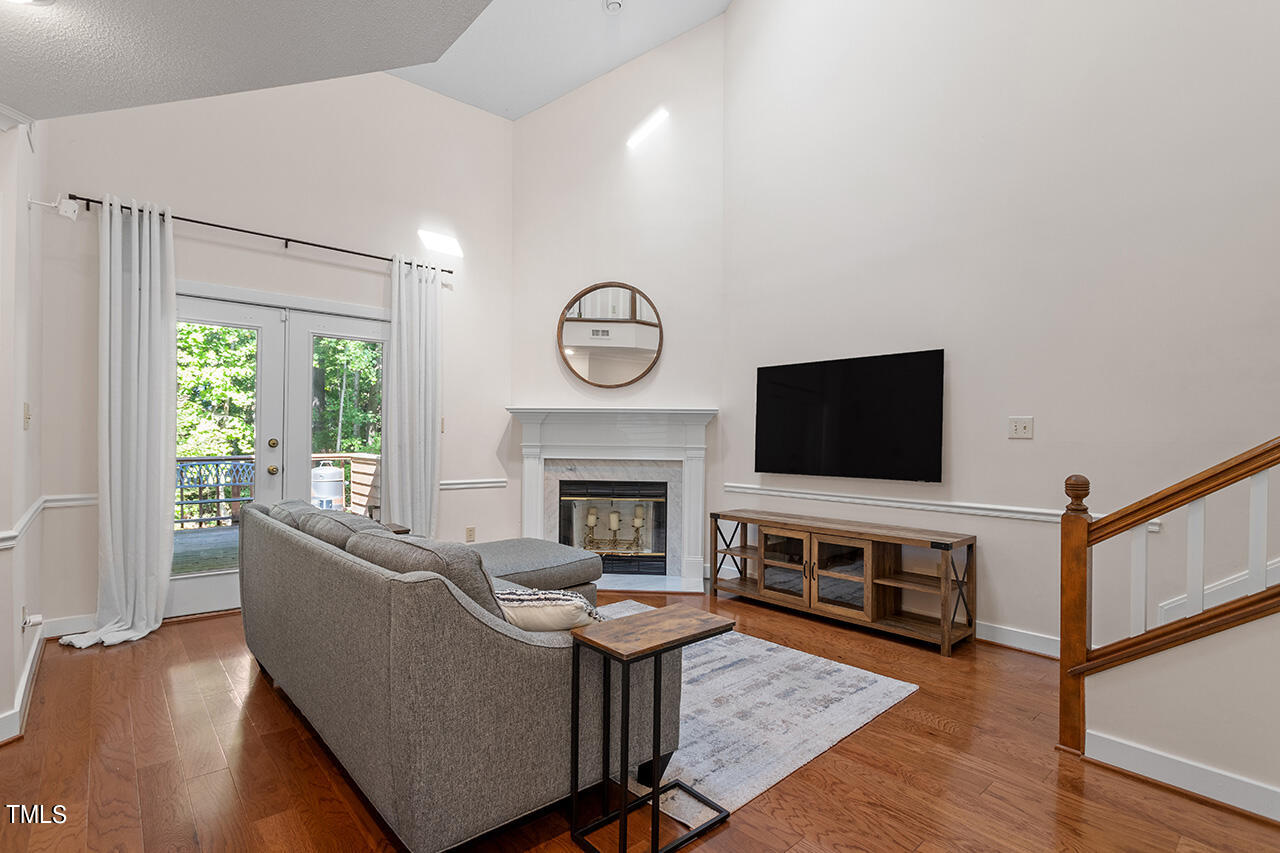 1433 Quarter Point Raleigh, NC 27615 - Photo 10 of 27 a living room with furniture a flat screen tv and a fireplace