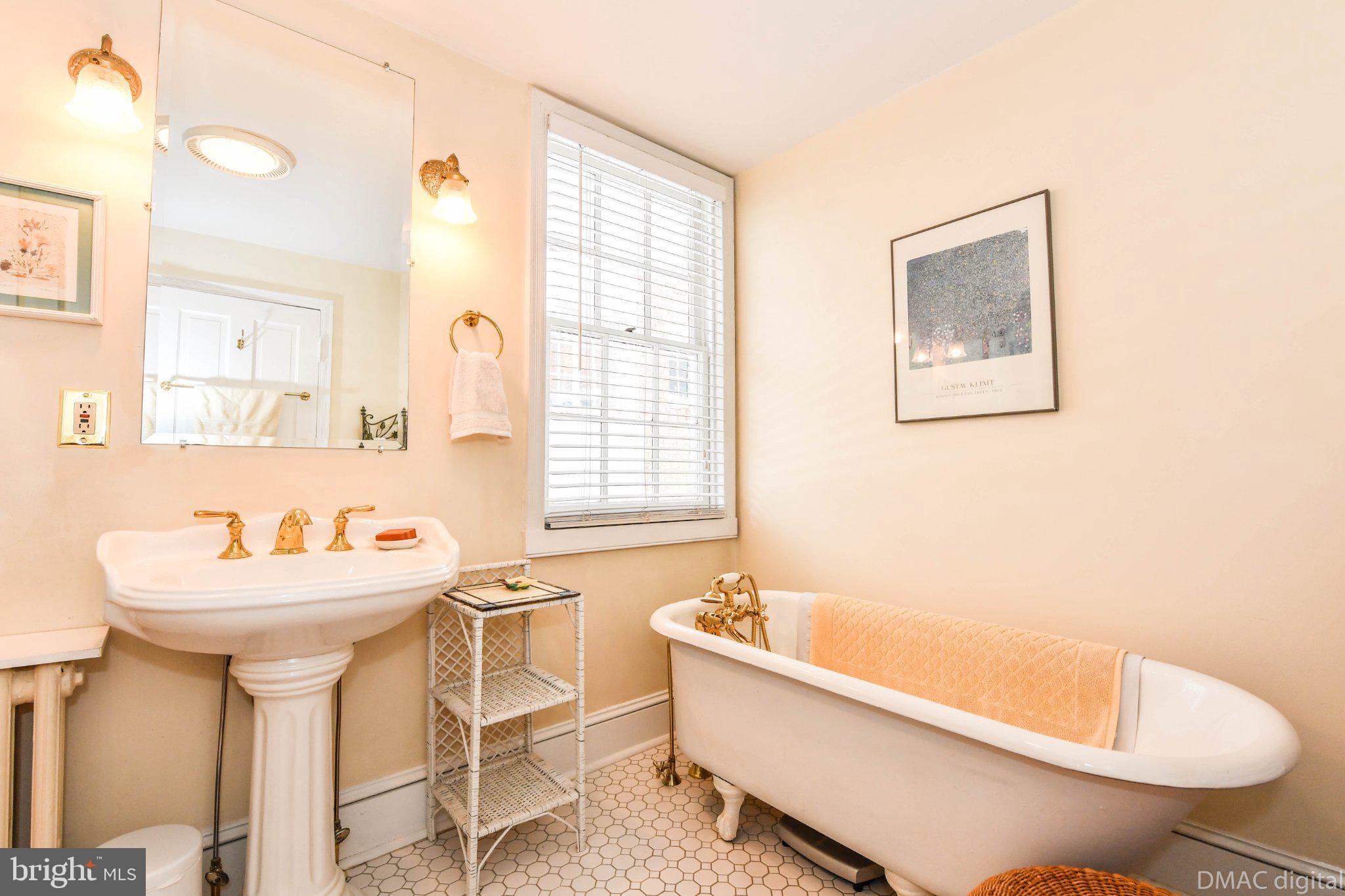 106 West 3rd Street Frederick, MD 21701 - Photo 15 of 46 a bathroom with a bathtub a sink and a window