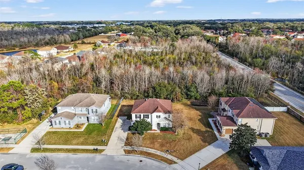an aerial view of residential houses with outdoor space and trees