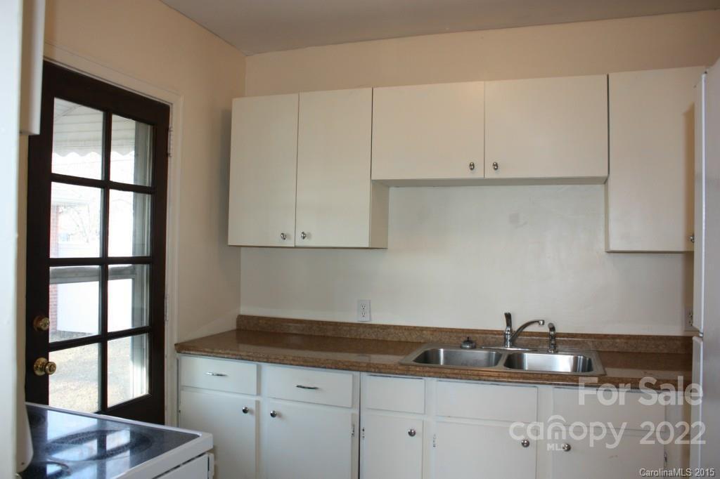 1436 Kimberly Road Charlotte, NC 28208 - Photo 5 of 6 a kitchen with granite countertop white cabinets and window
