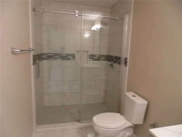 a bathroom with a shower a toilet and a sink