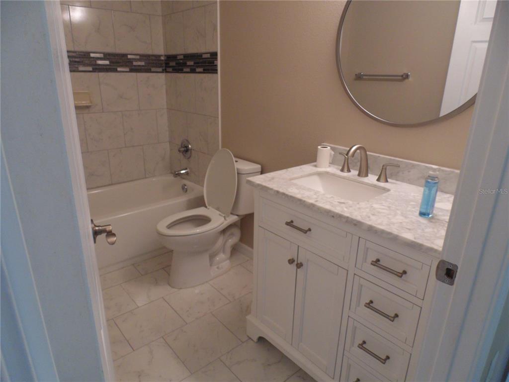 10856 Southwest 79th Avenue Ocala, FL 34476 - Photo 15 of 33 a bathroom with a granite countertop toilet a sink and a mirror