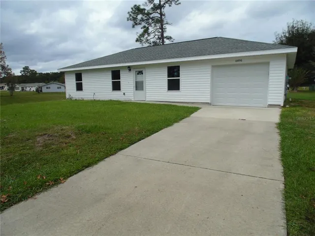 a front view of house with yard and tree