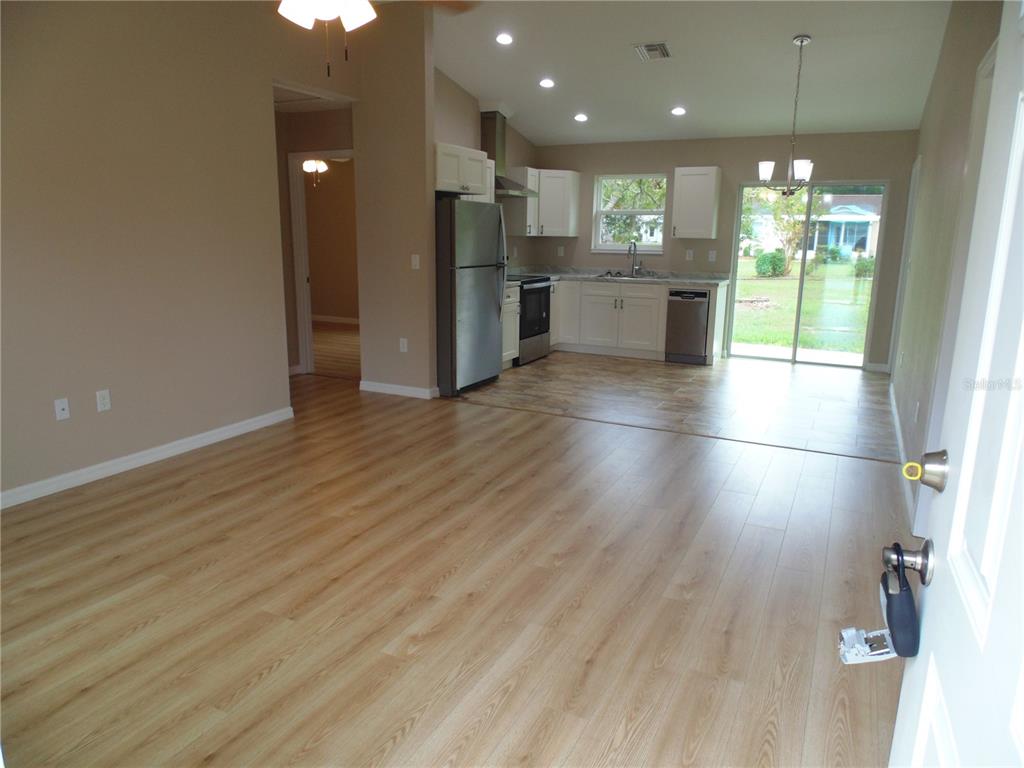 10856 Southwest 79th Avenue Ocala, FL 34476 - Photo 4 of 33 an open kitchen with a sink and dishwasher a refrigerator with wooden floor